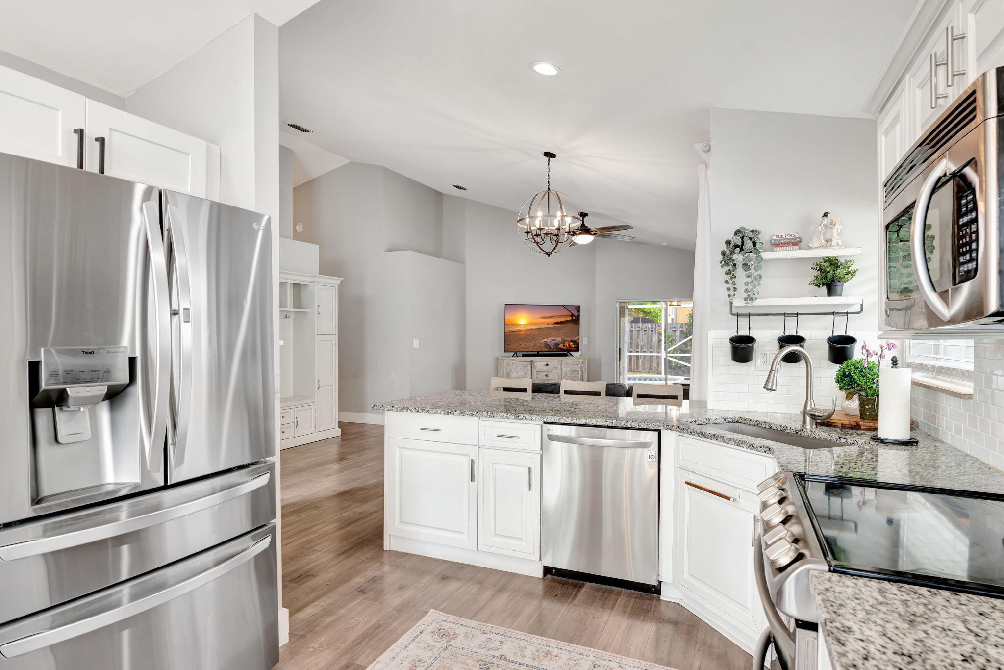 6247 Ungerer Street Jupiter, FL 33458 - Photo 18 of 36 a kitchen with stainless steel appliances a refrigerator sink and cabinets