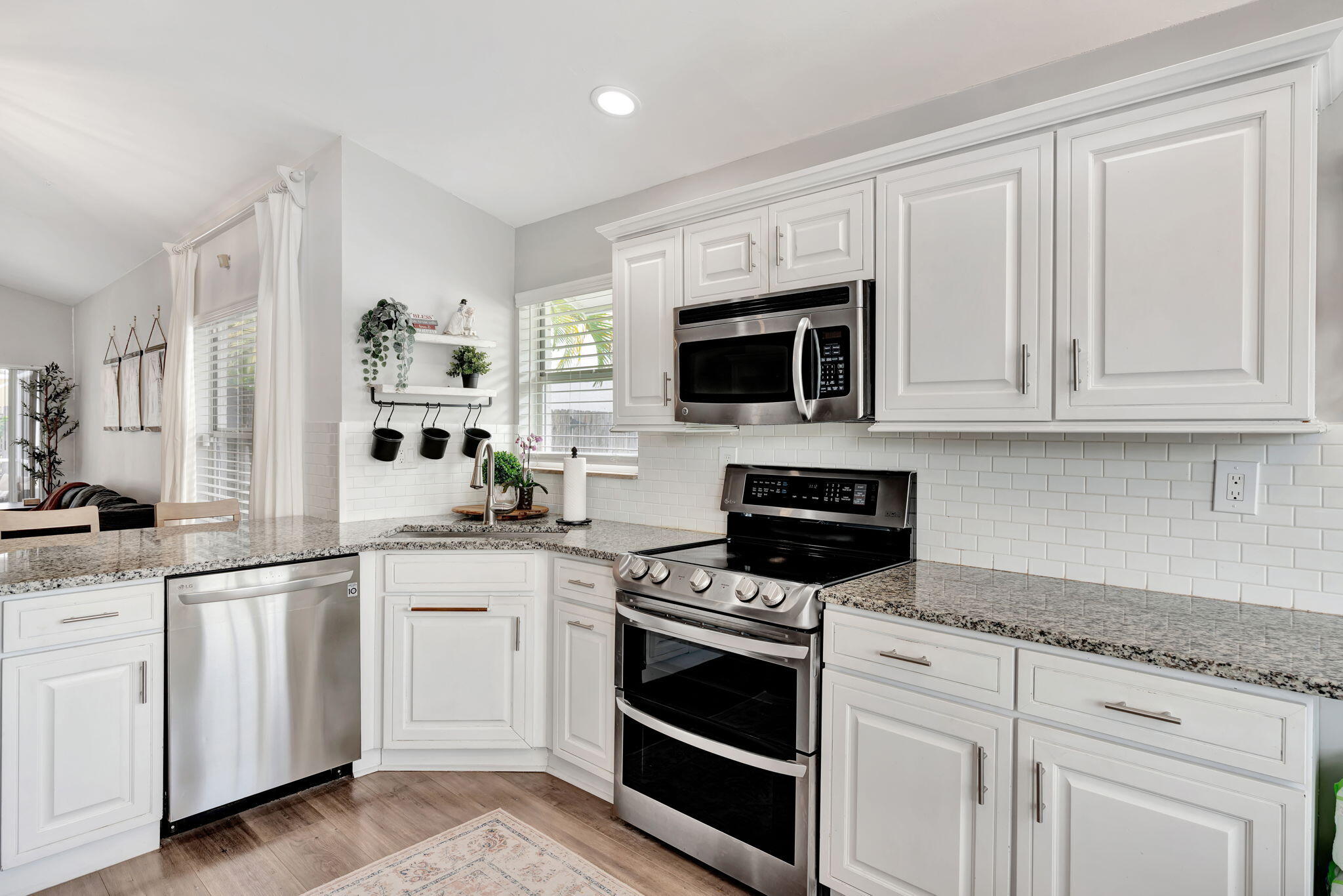 6247 Ungerer Street Jupiter, FL 33458 - Photo 19 of 36 a kitchen with white cabinets stainless steel appliances and sink