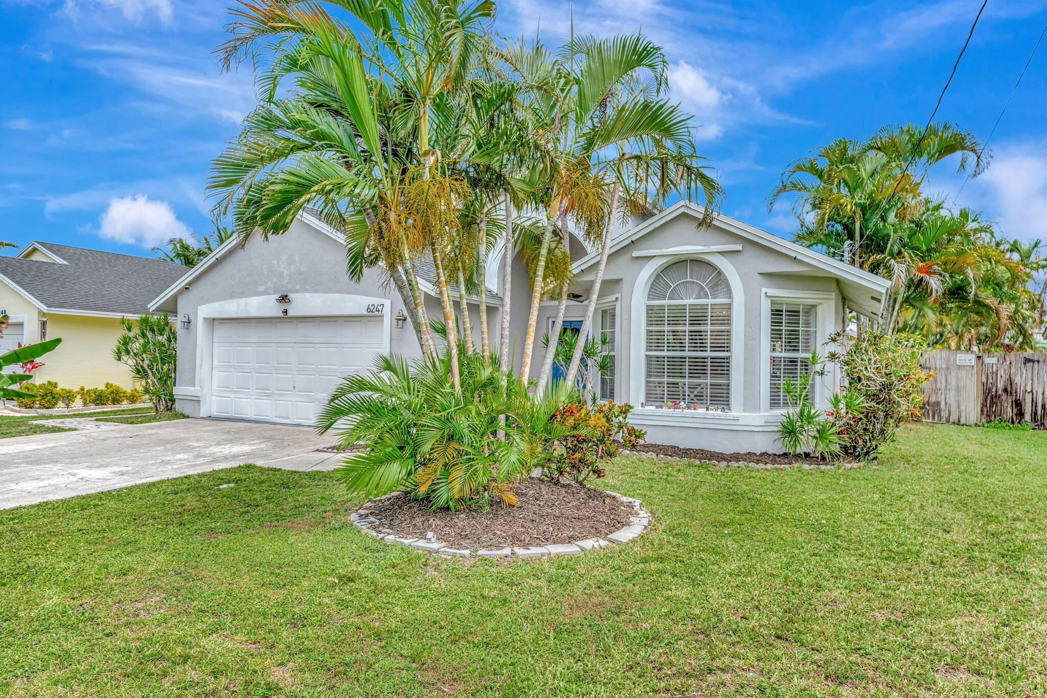 6247 Ungerer Street Jupiter, FL 33458 - Photo 3 of 36 a front view of a house with a yard and garage