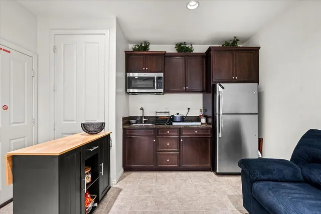 a kitchen with kitchen island a counter space a sink appliances and cabinets