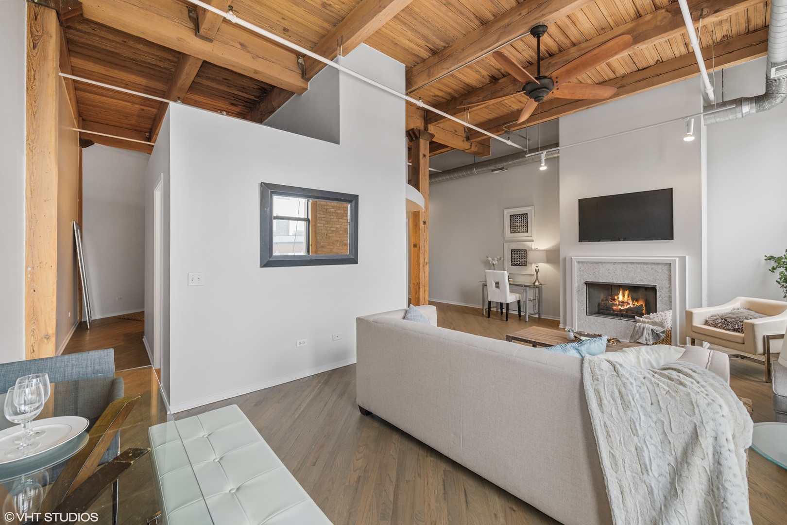 616 West Fulton Street, Unit 408 Chicago, IL 60661 - Photo 5 of 14 a living room with furniture a fireplace and a flat screen tv