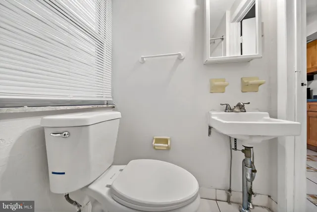 a white toilet sitting next to a bathroom sink