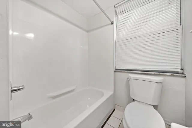 a white toilet sitting next to a bath tub