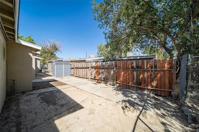 a view of backyard with wooden fence and trees