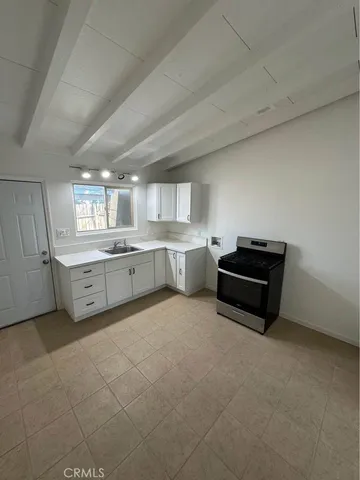 a kitchen with stainless steel appliances a stove a sink a counter top space and cabinets