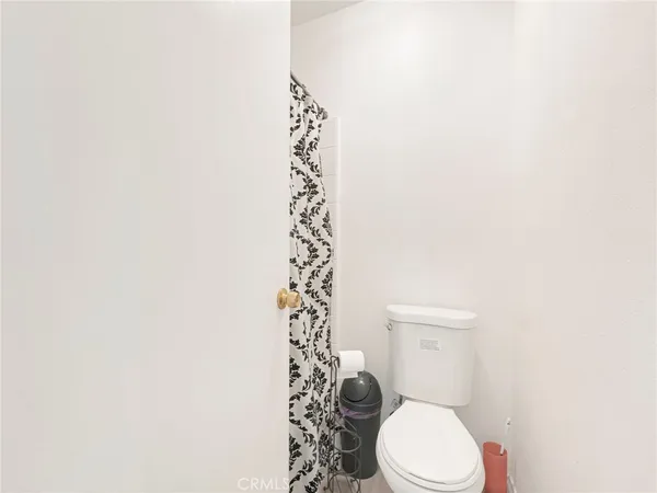 a white toilet sitting next to a shower curtain