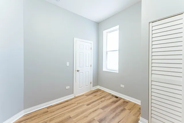 a view of empty room with wooden floor