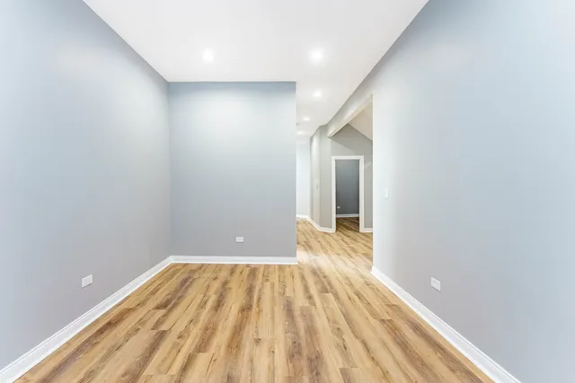 a view of a big room with wooden floor and brick walls