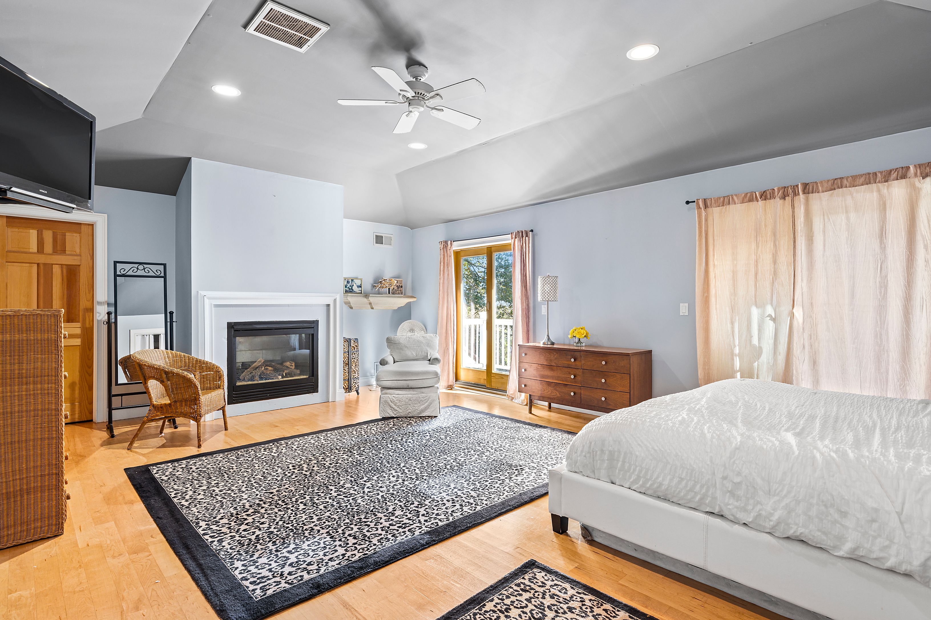 4 Bayberry Road Montauk, NY 11954 - Photo 11 of 29 a bedroom with a bed a fireplace and a chandelier