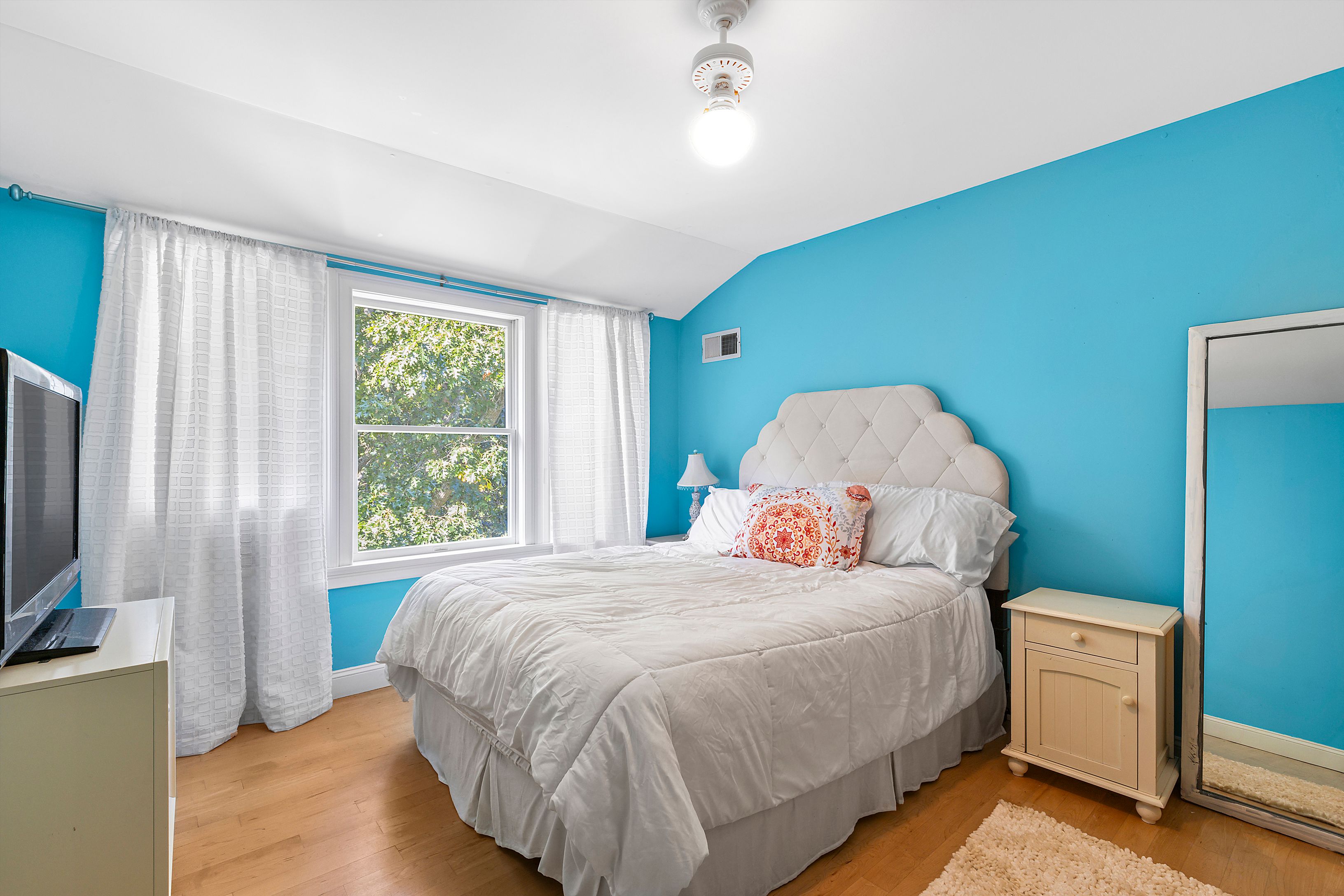 4 Bayberry Road Montauk, NY 11954 - Photo 13 of 29 a bedroom with a bed and a flat tv screen on dresser