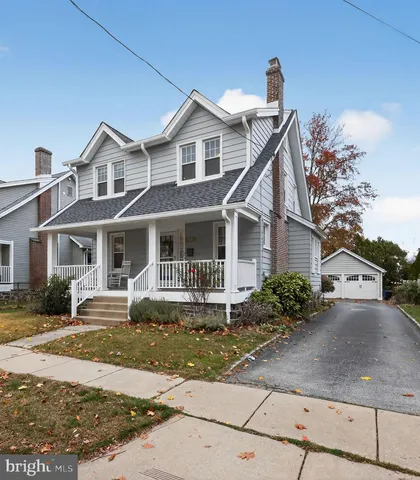 a front view of a house with a yard and potted plants