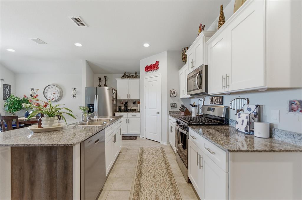 316 Sculptors Crossing Springtown, TX 76082 - Photo 9 of 19 a kitchen with granite countertop a sink stove and cabinets
