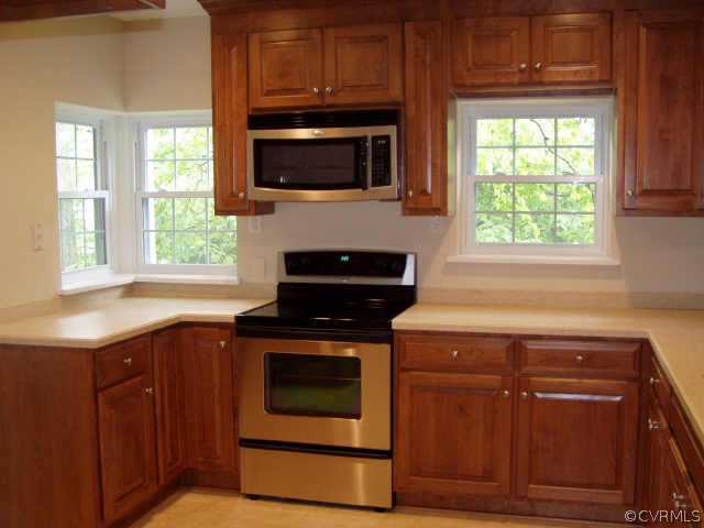 7731 Brookside Road Richmond, VA 23229 - Photo 5 of 7 a kitchen with stainless steel appliances granite countertop wooden cabinets stove top oven and sink