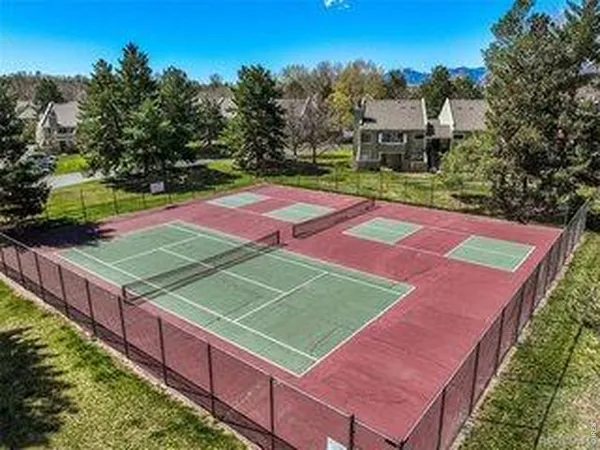 a view of a tennis ground with large trees