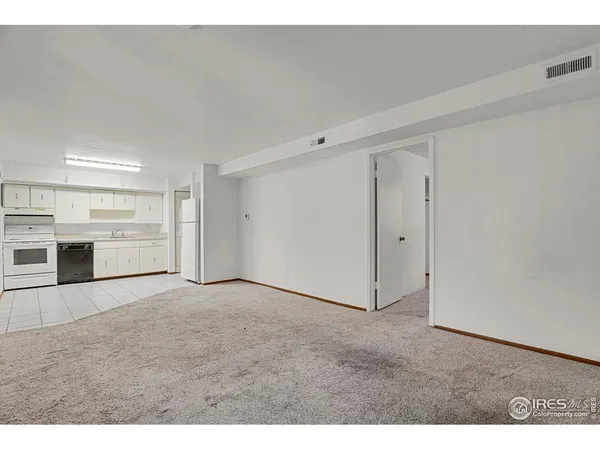a view of an empty room with a kitchen