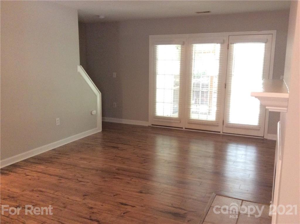 6614 Bevington Ridge Road, Unit B Charlotte, NC 28277 - Photo 2 of 16 an empty room with wooden floor and windows with curtains