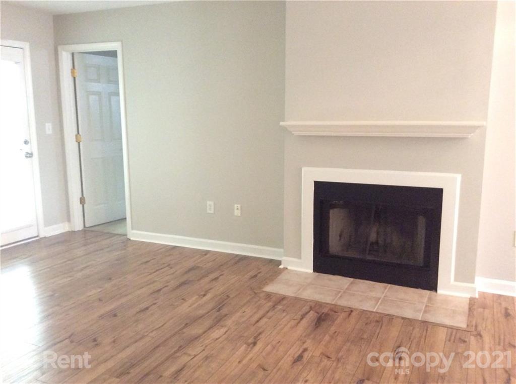 6614 Bevington Ridge Road, Unit B Charlotte, NC 28277 - Photo 3 of 16 a view of an empty room with wooden floor and a fireplace