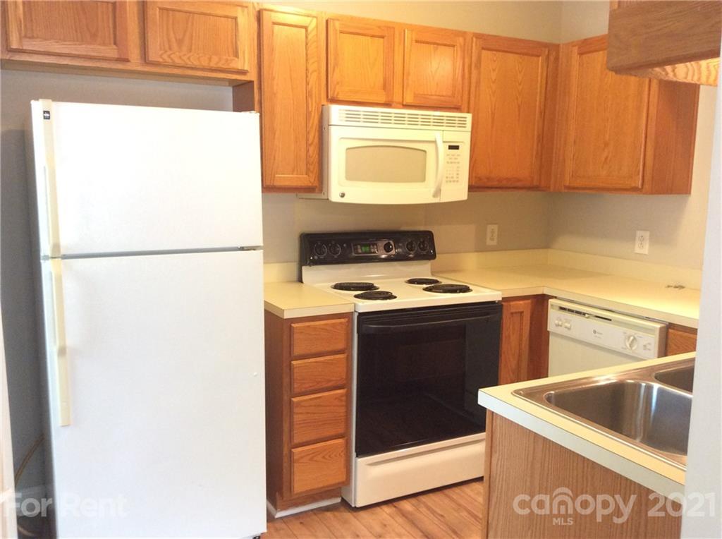 6614 Bevington Ridge Road, Unit B Charlotte, NC 28277 - Photo 6 of 16 a kitchen with stainless steel appliances granite countertop a sink stove and refrigerator