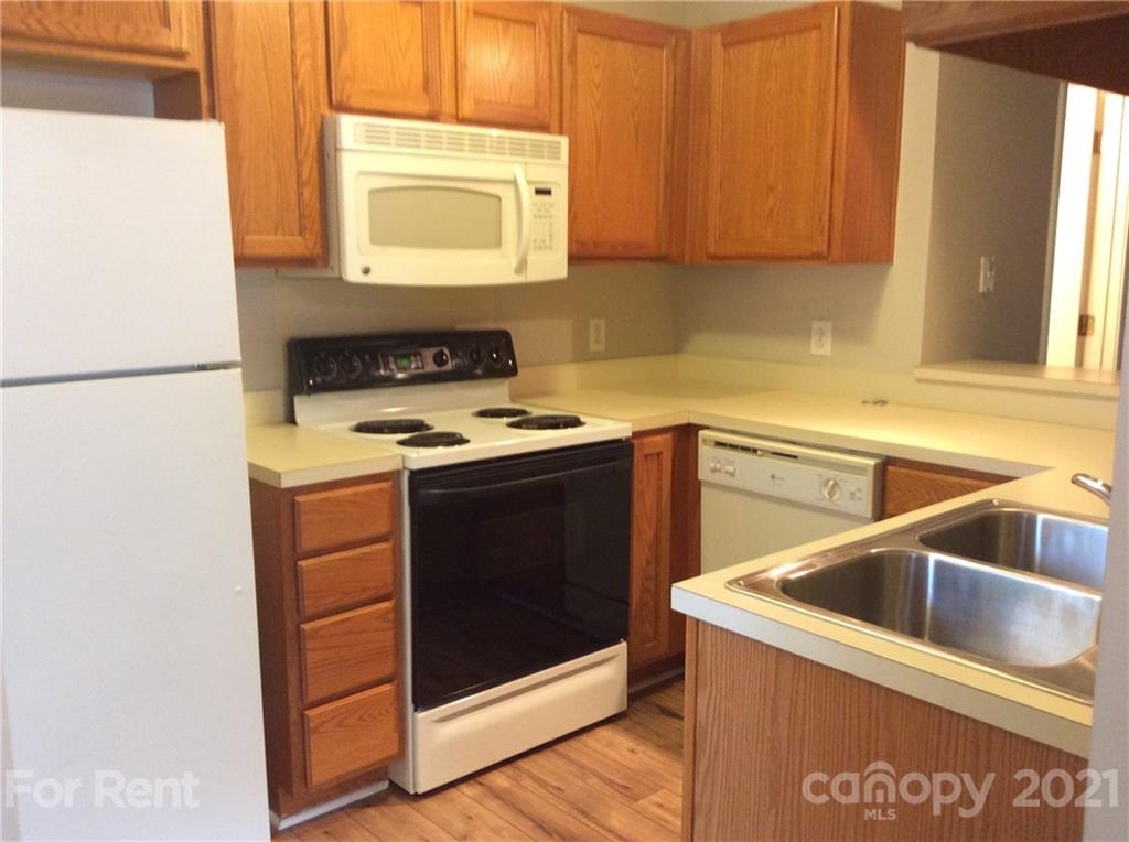 6614 Bevington Ridge Road, Unit B Charlotte, NC 28277 - Photo 7 of 16 a kitchen with a sink a stove and a microwave