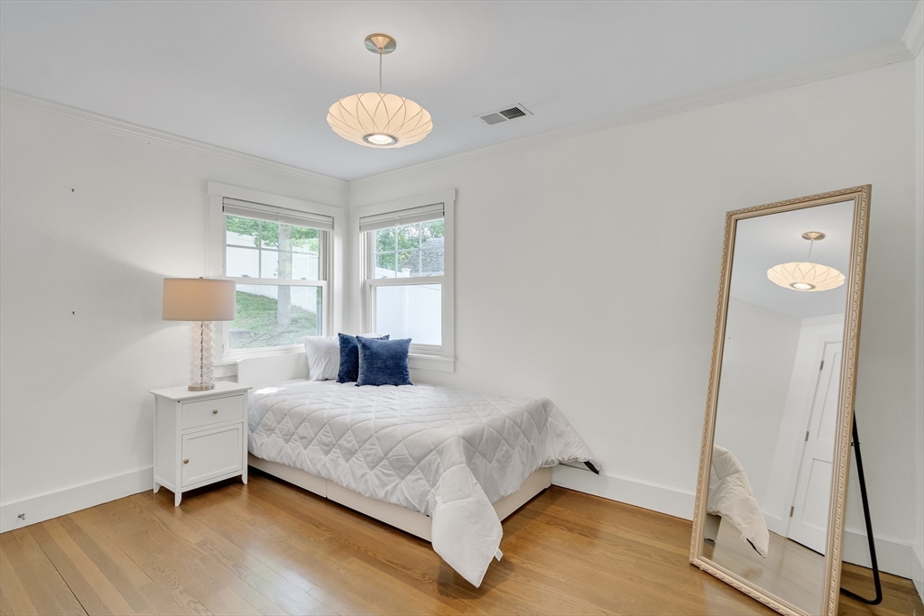 20 Lila Road Boston, MA 02130 - Photo 22 of 28 a bedroom with a bed and a chandelier