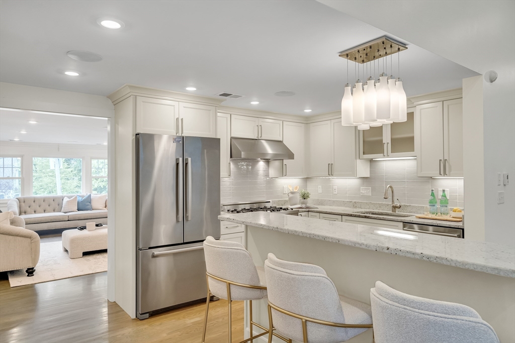 20 Lila Road Boston, MA 02130 - Photo 8 of 28 a kitchen with stainless steel appliances granite countertop a refrigerator a sink a stove a dining table and chairs