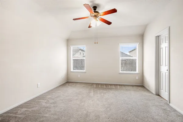 an empty room with closet and a ceiling fan