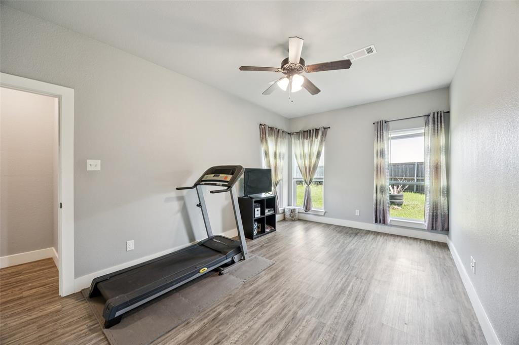 709 Coblestone Circle Mabank, TX 75147 - Photo 11 of 24 a view of a room with gym equipment and a ceiling fan
