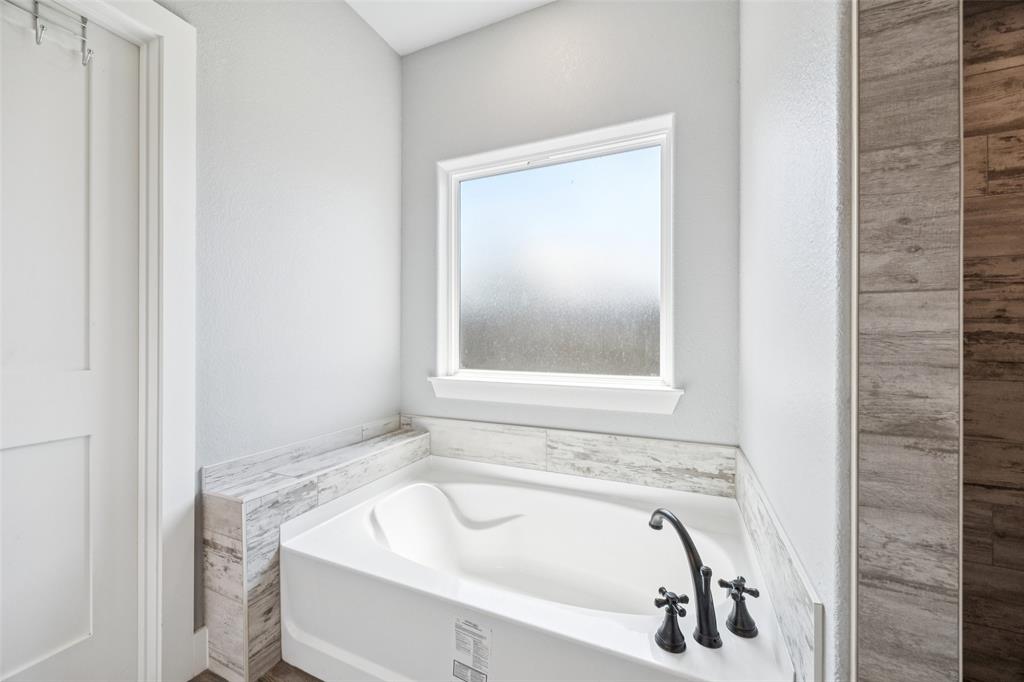 709 Coblestone Circle Mabank, TX 75147 - Photo 14 of 24 a bathroom with a tub and sink