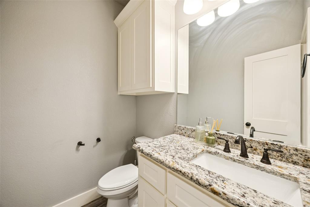 709 Coblestone Circle Mabank, TX 75147 - Photo 19 of 24 a bathroom with a granite countertop sink a toilet and a mirror