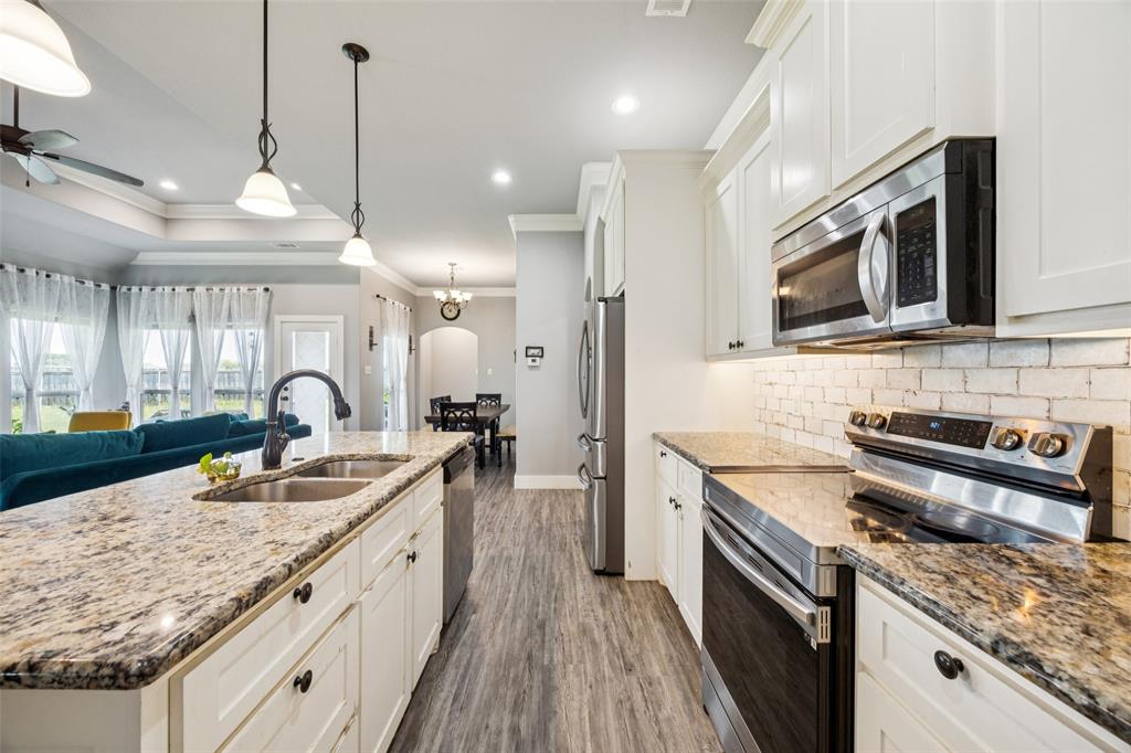709 Coblestone Circle Mabank, TX 75147 - Photo 8 of 24 a large kitchen with stainless steel appliances granite countertop a stove a sink and a microwave