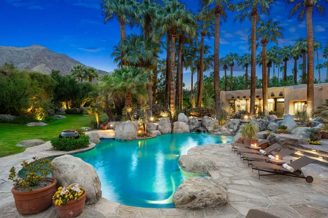 a view of a backyard with swimming pool and furniture