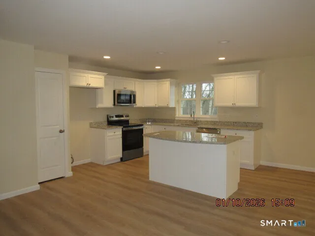 a kitchen with granite countertop a sink and cabinets