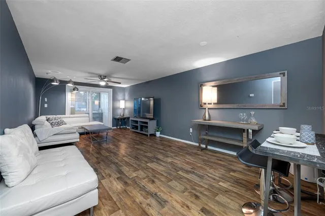 a living room with furniture and a wooden floor