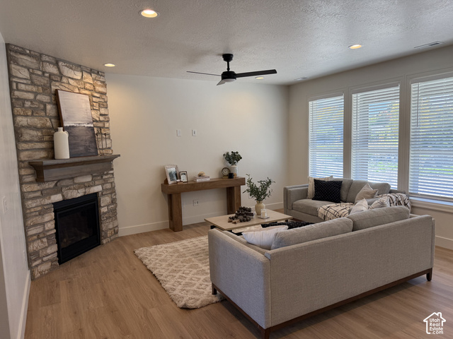 658 West 500 South, Unit 2 Logan, UT 84321 - Photo 3 of 18 Stone-clad fireplace with mantel, recessed lighting, ceiling fan, wood-finish flooring, and multiple windows with blinds