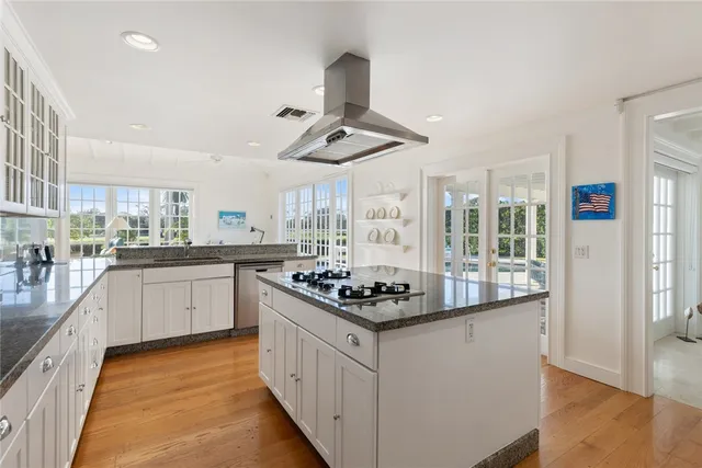 a kitchen with stainless steel appliances kitchen island granite countertop a sink and cabinets