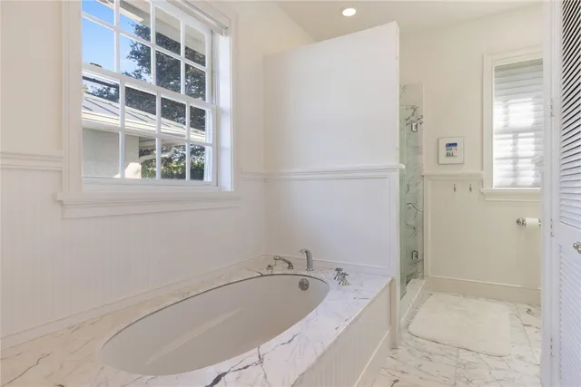 a white bath tub sitting next to a shower