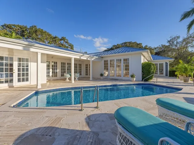 a view of a house with swimming pool and sitting area