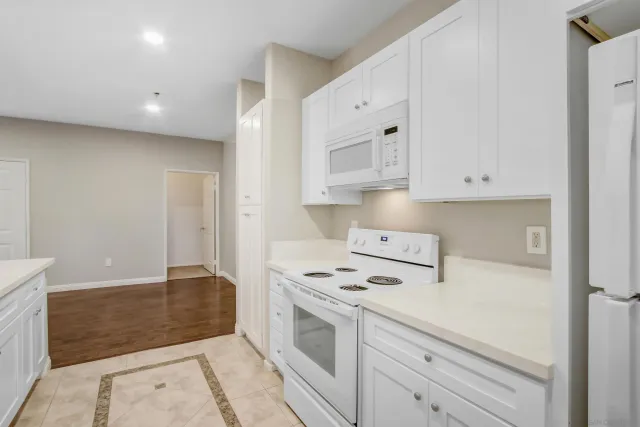 a kitchen with white cabinets and white appliances