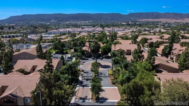 an aerial view of residential houses with outdoor space and trees