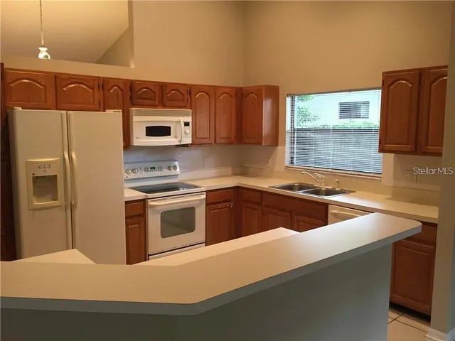 a kitchen with stainless steel appliances a sink a stove a microwave a counter top space and cabinets