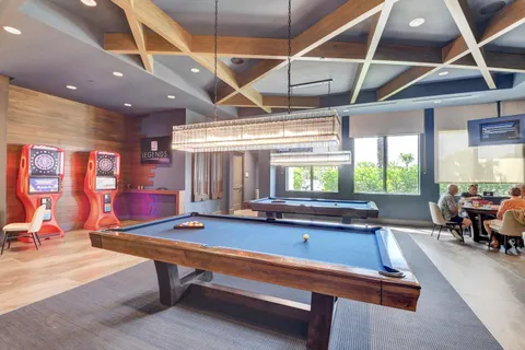 a room with pool table and windows