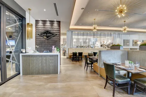 a living room with couches a dining table and kitchen view with wooden floor