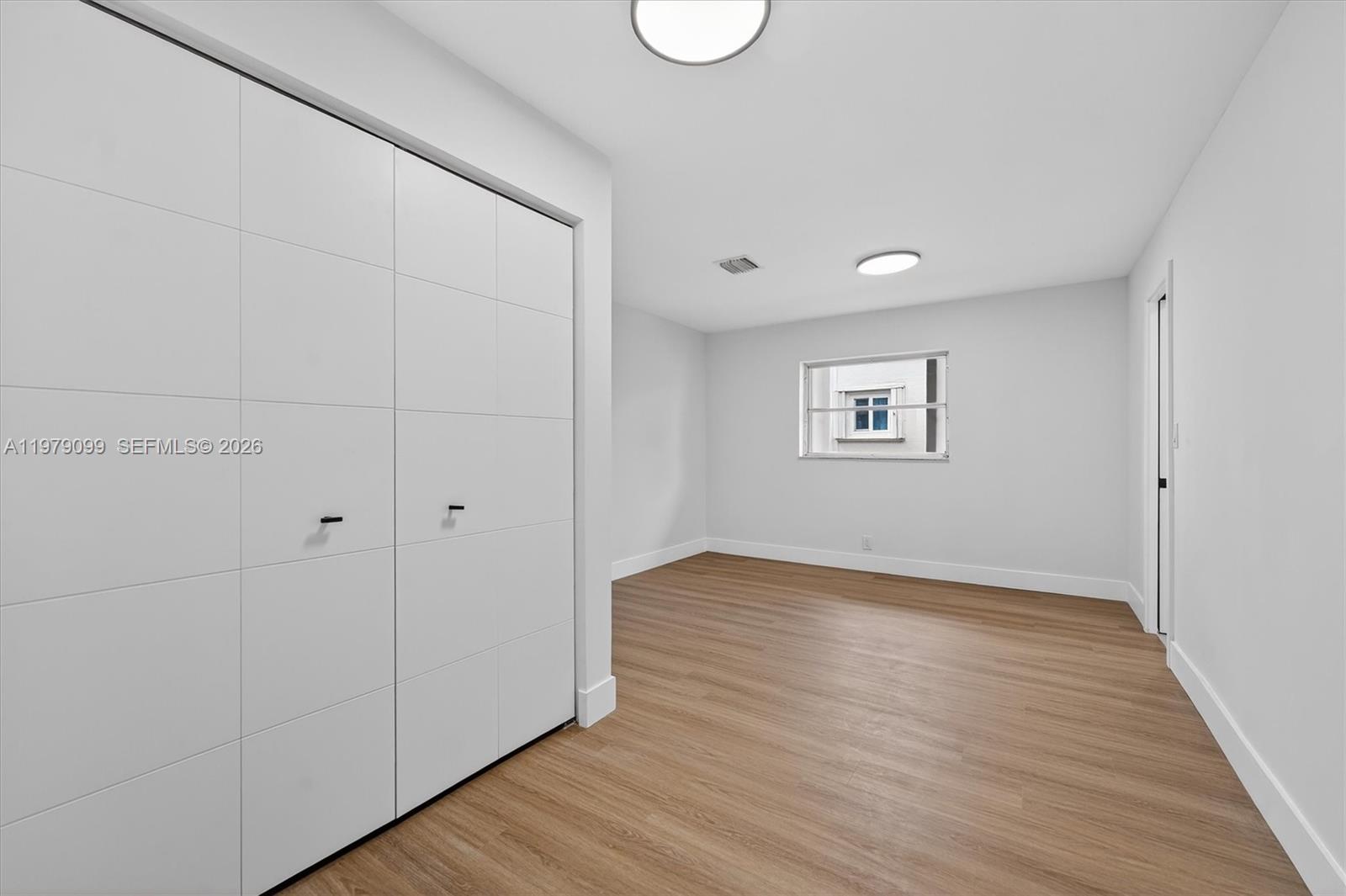 8941 Northwest 13th Street Plantation, FL 33322 - Photo 17 of 26 a view of an empty room with wooden floor and a window