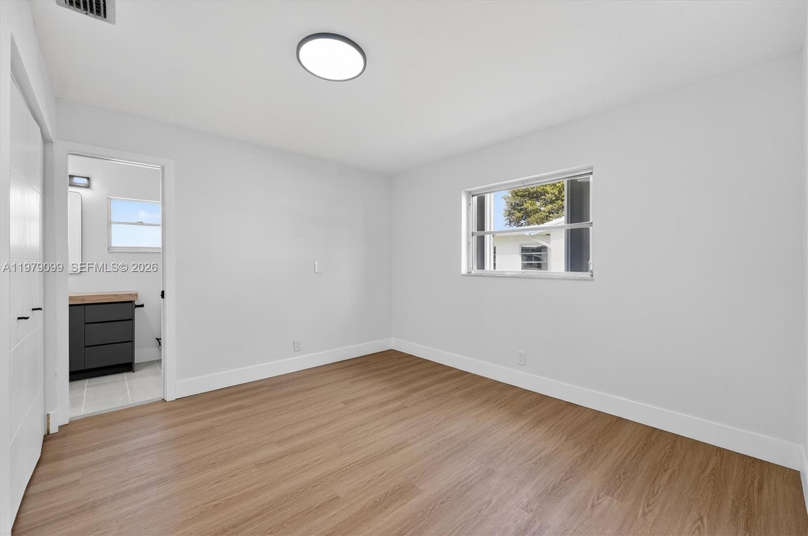 8941 Northwest 13th Street Plantation, FL 33322 - Photo 21 of 26 an empty room with wooden floor cabinet and windows