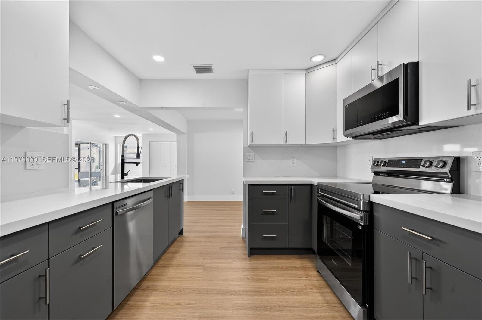 8941 Northwest 13th Street Plantation, FL 33322 - Photo 5 of 26 a kitchen with stainless steel appliances granite countertop a sink and a stove top oven