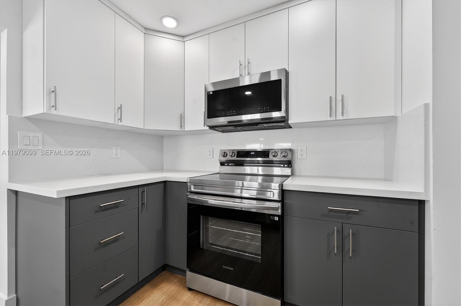 8941 Northwest 13th Street Plantation, FL 33322 - Photo 6 of 26 a kitchen with stainless steel appliances granite countertop a stove a microwave and cabinets