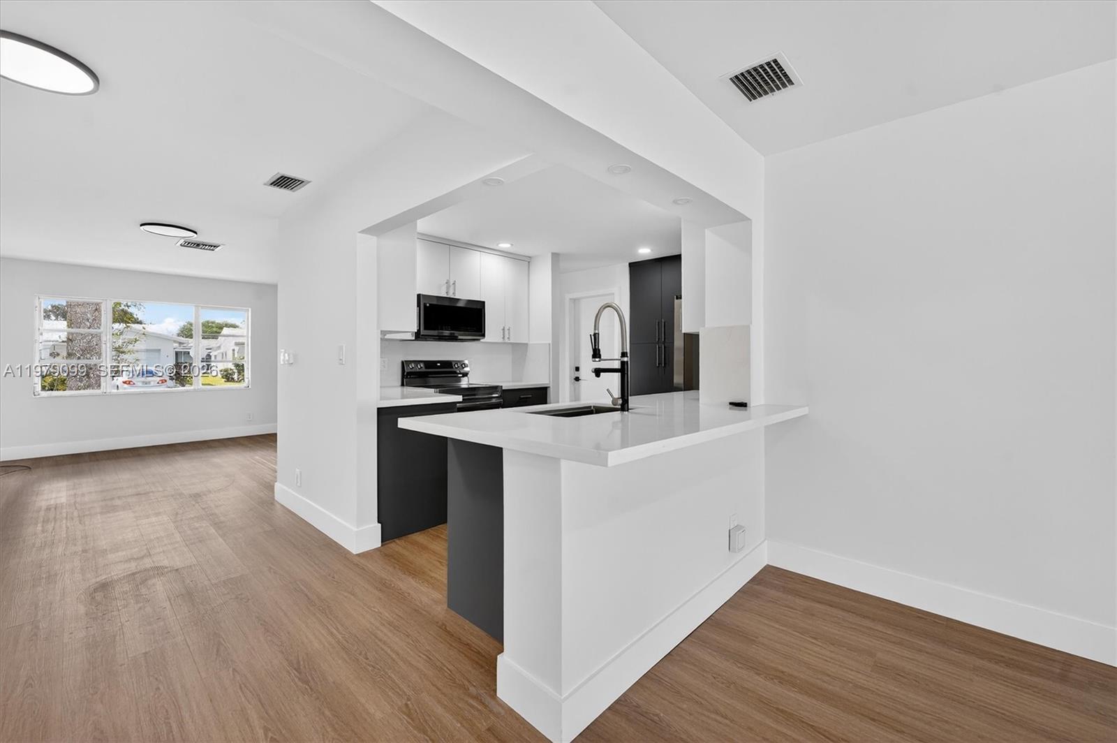 8941 Northwest 13th Street Plantation, FL 33322 - Photo 7 of 26 a kitchen with a refrigerator and a stove top oven