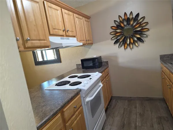 a view of a hallway with wooden floor and closet
