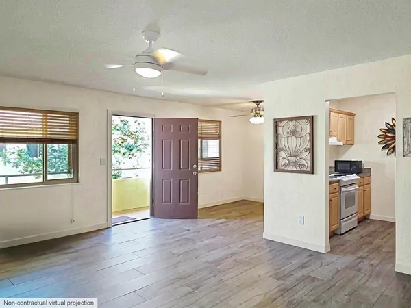 a view of a kitchen with a stove cabinets potted plants and wooden floor
