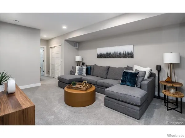 a living room with furniture a rug and a lamp